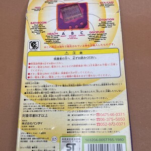 May include: A purple and pink Tamagotchi electronic pet toy with a screen that reads "Meal Snack". The box is pink and white with Japanese text and instructions. The box includes a warning to parents to read the instructions.