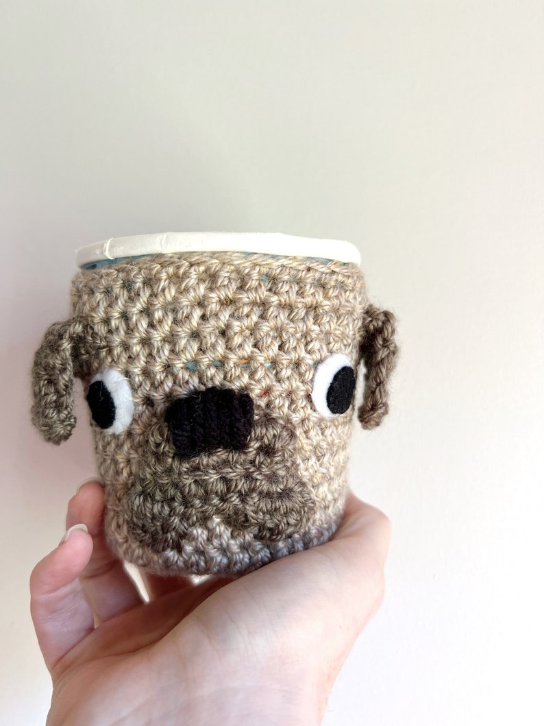 Pug dog crochet cozy covering a Ben & Jerry’s Pint sized ice cream tub