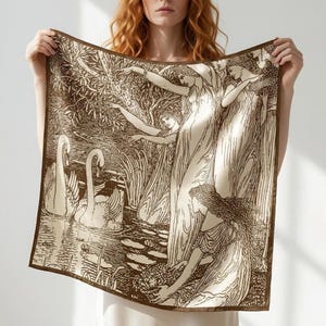 May include: A square silk scarf with a sepia-toned illustration of women and swans. The scarf has a brown border and a detailed drawing of figures and nature elements. The scarf is held up by a person. The scarf is a square shape.