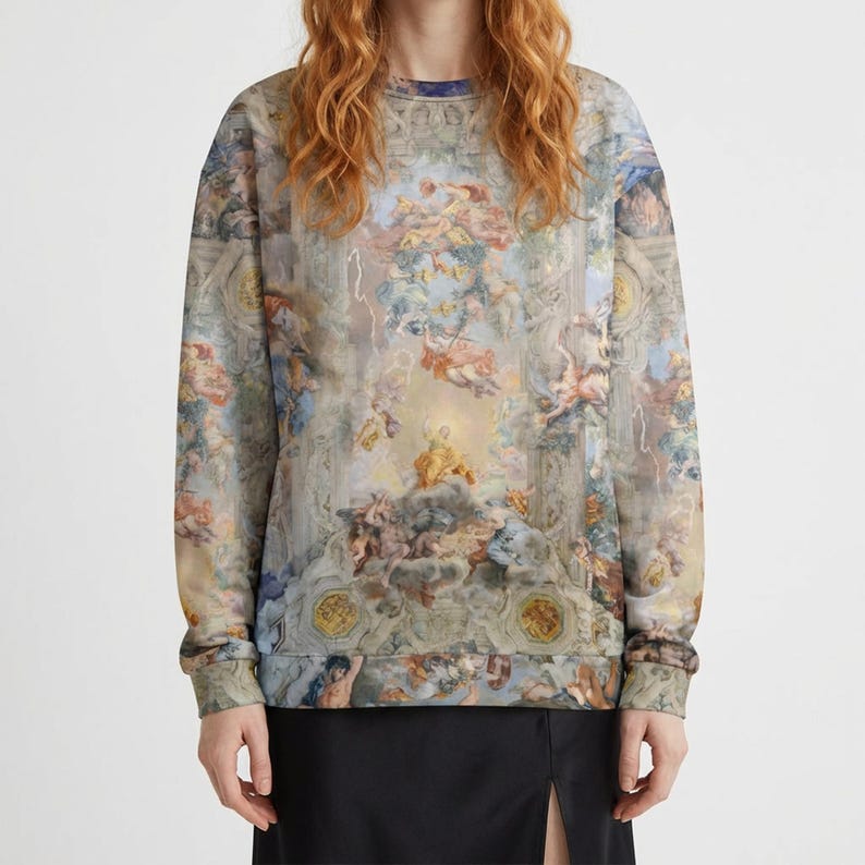 May include: Crew neck sweatshirt featuring a Renaissance-style ceiling painting design. The long-sleeved top has a beige, blue, and gold color palette with detailed figures and architectural elements. The cuffs and neckline are ribbed.