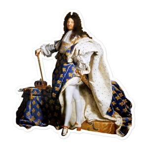 以下が含まれることがあります： 王族の衣装を着た人物の肖像画が描かれたステッカー。白いシャツ、青と金の模様のローブ、金色のアクセントが付いた白いケープを着用しています。王冠と王笏も存在します。