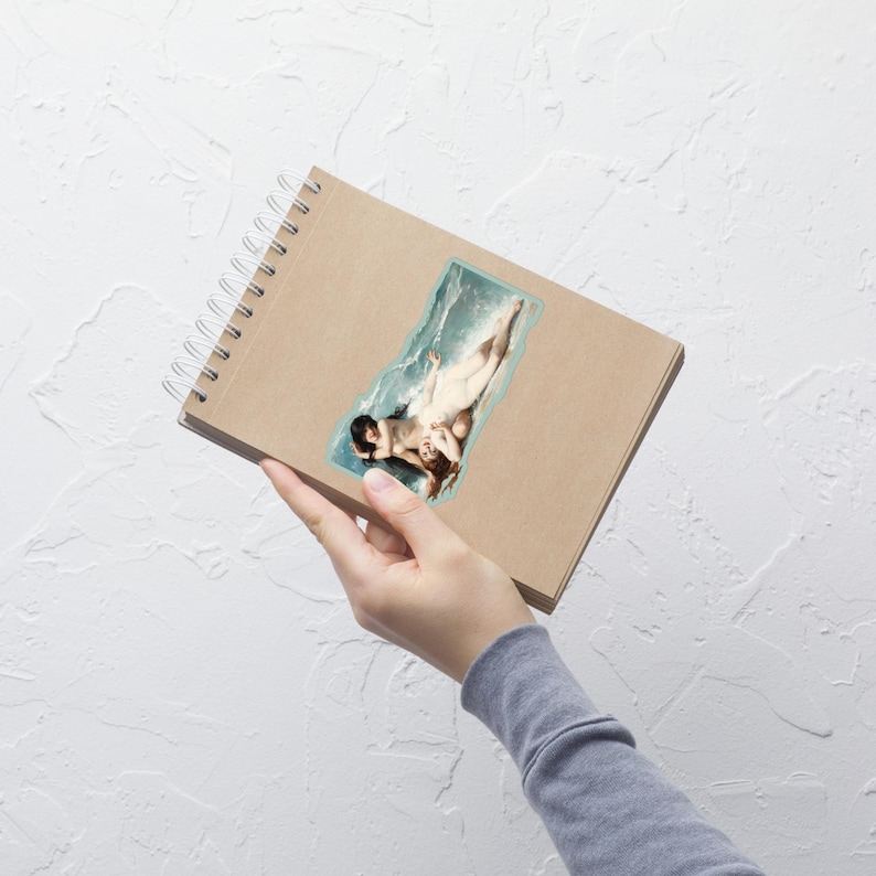 K&ouml;nnte beinhalten: Ein Aufkleber mit einem klassischen Gem&auml;lde von zwei Figuren im Wasser. Das Kunstwerk ist von einem hellblauen Rahmen umgeben. Der Aufkleber befindet sich auf einem braunen Spiralnotizbuch.