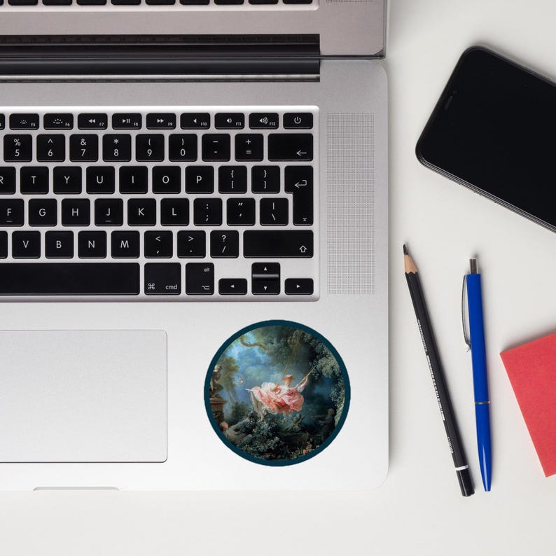 May include: A round sticker featuring a classical painting of a woman in a pink dress on a swing. The artwork is set in a lush green forest with a blue sky background. The sticker is on a laptop.
