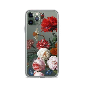 May include: Clear phone case featuring a floral still life design with red, white, pink, and orange flowers, and a butterfly. The case has a clear border and a dark green background.