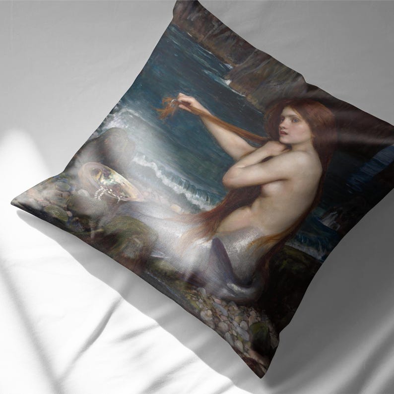 Puede incluir: Una pintura de una sirena con el pelo largo y rojo, sentada en las rocas junto al mar. Est&aacute; sujetando un mech&oacute;n de pelo en la mano y mirando hacia un lado. El mar es de un color azul oscuro y hay olas rompiendo contra las rocas.