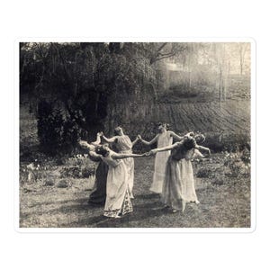 May include: Black and white sticker featuring a vintage photograph of six people in long dresses holding hands in a circle. They are in a grassy area with a large tree in the background. The image has a sepia tone.