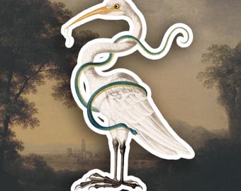 Peut inclure: Un autocollant représentant un oiseau blanc avec un long bec jaune et un serpent vert et bleu enroulé autour de son corps. L'oiseau est placé sur un fond de peinture de paysage avec des arbres et une ville lointaine.
