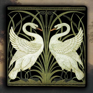 May include: A decorative square featuring two white swans facing each other, set against a black background. The swans have detailed feather patterns and orange beaks. Green and gold stylized reeds and foliage surround the swans, with a decorative border.