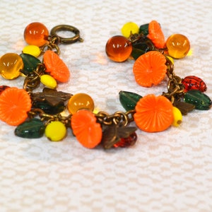 Vintage Charm Bracelet, with burnt orange glass balls , golden melon bead spacers, yellow flowers, green glass leaves and copper bee charms