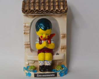 Figura de porcelana vintage, reciclada, repintada y coloreada de un niño zen.