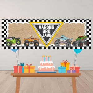 Puede incluir: Una pancarta con un borde a cuadros blanco y negro y un fondo beige. La pancarta presenta cuatro ilustraciones de monster trucks y el texto "Aarons 3rd Jam". Una mesa contiene un pastel, regalos y globos.