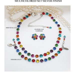 Puede incluir: Un conjunto de joyas multicolores que incluye un collar, una pulsera y pendientes de clip con forma de flor. Las joyas est&aacute;n hechas con acabado plateado y cristales de Swarovski. El collar y la pulsera est&aacute;n hechos con cristales redondos de 8 mm en un patr&oacute;n de arco&iacute;ris. Los pendientes de clip con forma de flor est&aacute;n hechos con cristales m&aacute;s peque&ntilde;os en un patr&oacute;n de arco&iacute;ris.