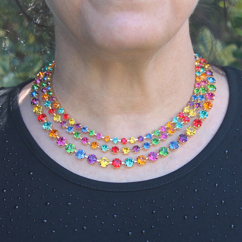 Puede incluir: Un collar de varias capas con cuentas de cristal de colores arco&iacute;ris. El collar est&aacute; hecho de cadena dorada y presenta una variedad de colores, incluyendo rojo, naranja, amarillo, verde, azul, &iacute;ndigo y violeta.