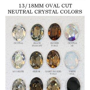 May include: A collection of twelve 13/18mm oval cut crystals in neutral colors labeled as Crystal, Black Diamond, Smoked Topaz, Crystal AB, Moonlite, Greige, Light Smoked Topaz, White Opal, Silver Shade, Smokey Quartz, Golden Shadow, and Jet Black.