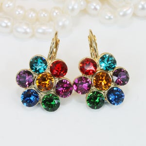 Puede incluir: Un par de pendientes de oro en forma de flor con piedras de cristal de colores. Las piedras est&aacute;n dispuestas en un patr&oacute;n de arco&iacute;ris, con piedras rojas, naranjas, amarillas, verdes, azules y moradas.