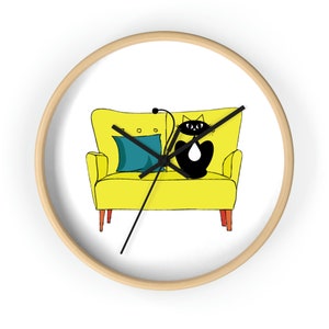May include: A yellow armchair with a black cat sitting on it. The armchair has a teal blue pillow and wooden legs. The cat has a white patch on its chest.