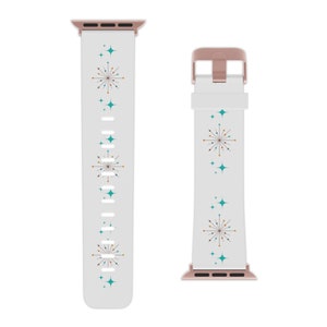 May include: White Apple Watch band with a rose gold buckle. The band has a repeating pattern of turquoise and gold stars and a stylized burst design.