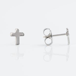 May include: A pair of silver cross stud earrings. The earrings have a simple, minimalist design.