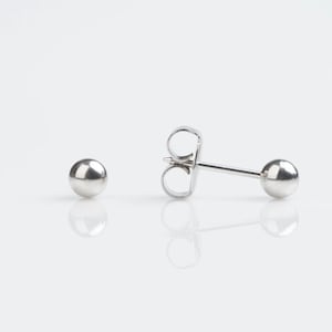 May include: A pair of silver ball stud earrings. The earrings are simple and classic, and they would make a great gift for any occasion.