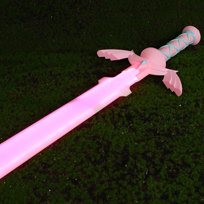 Puede incluir: Una espada de pl&aacute;stico rosa y azul con una luz rosa brillante. La espada tiene un dise&ntilde;o alado y un detalle de cinta azul.