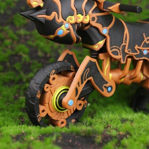 Close-up image of the suspension detail on the Master Cycle Zero 3D print from Zelda: Breath of the Wild and Tears of the Kingdom. This shot highlights the precision of the spring mechanism, showing how it adds realistic functionality to the display model. The detailing captures both the magical elements and advanced design of the bike, appealing to gamers, collectors, and fans of fantasy-themed engineering designs inspired by video game worlds.