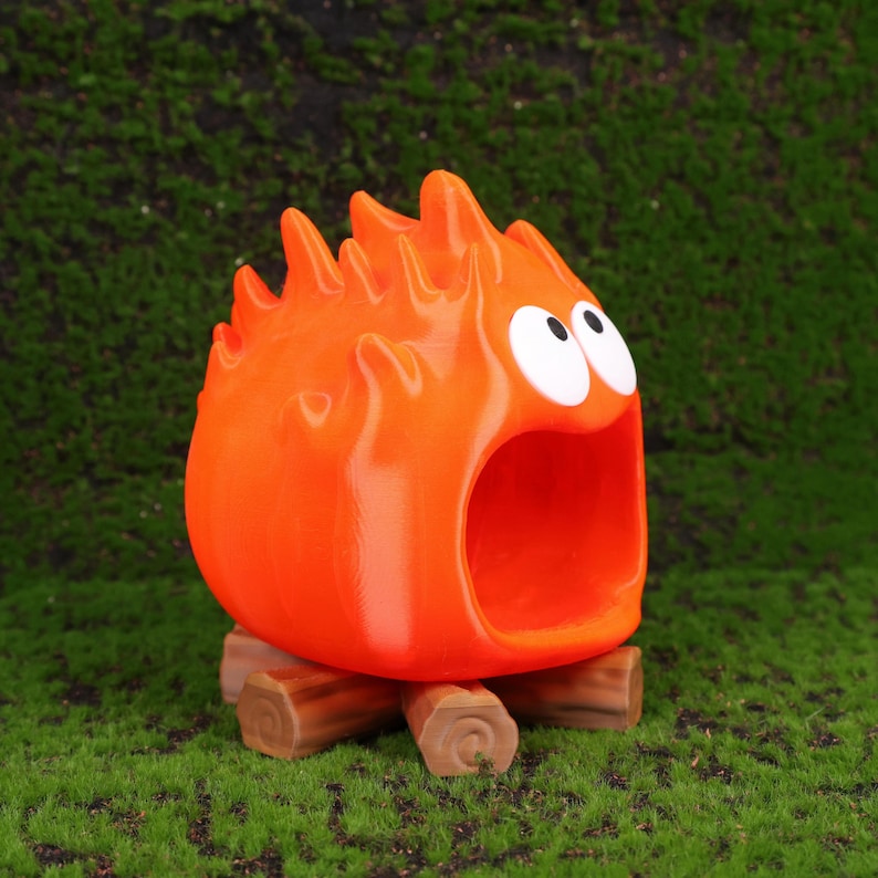 Scene showing the Calcifer fire demon desk organizer open with small gadgets like flash drives and memory cards stored inside. The design brings Howl’s Moving Castle magic to any desk or workspace. Ideal for students, professionals, or anime fans, this organizer combines whimsical aesthetics with daily practicality and makes an eye-catching gift option for holiday seasons.