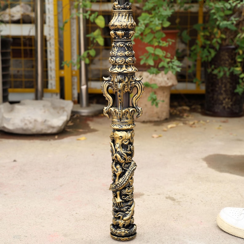 May include: Ornate black and gold decorative pole with intricate carvings. The pole features detailed relief sculptures of dragons and other mythical creatures. The design includes decorative flourishes and a detailed base.