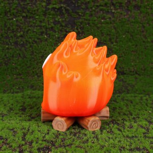 Scene showing the Calcifer fire demon desk organizer open with small gadgets like flash drives and memory cards stored inside. The design brings Howl’s Moving Castle magic to any desk or workspace. Ideal for students, professionals, or anime fans, this organizer combines whimsical aesthetics with daily practicality and makes an eye-catching gift option for holiday seasons.