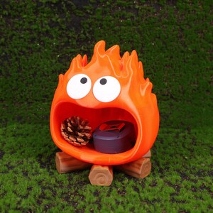 Close-up image of the Fire Demon Calcifer 3D printed storage box showing detailed craftsmanship, smooth surface finish, and the vibrant orange color. Designed as a functional desktop organizer, the product offers a practical yet fun solution to storing small office essentials. Inspired by Howl’s Moving Castle, it makes an excellent collectible item or anime-themed gift for birthdays, holidays, or special occasions.