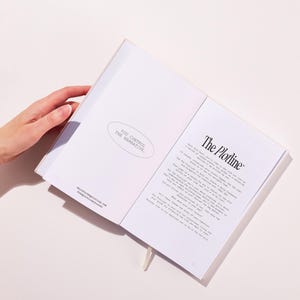 以下が含まれることがあります： 「The Plotline」と「You control the narrative.」というテキストが書かれた白いジャーナルが開かれています。ジャーナルは、プロットと自分のストーリーを作成する方法について書かれたページを開いています。
