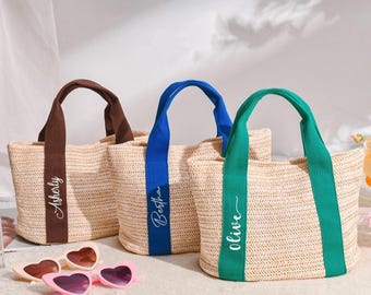 May include: Three woven tote bags with contrasting handles and vertical stripes. The handles are brown, blue, and green. Each bag has a name printed on the front in a cursive font: Asherly, Bertha, and Olive. Heart-shaped sunglasses are in the foreground.