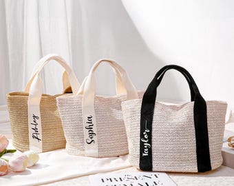 May include: Three woven tote bags with handles. The bags are in neutral tones, with one in natural straw, one in light beige, and one in light beige with black accents. Each bag has a white band with a name printed on it.