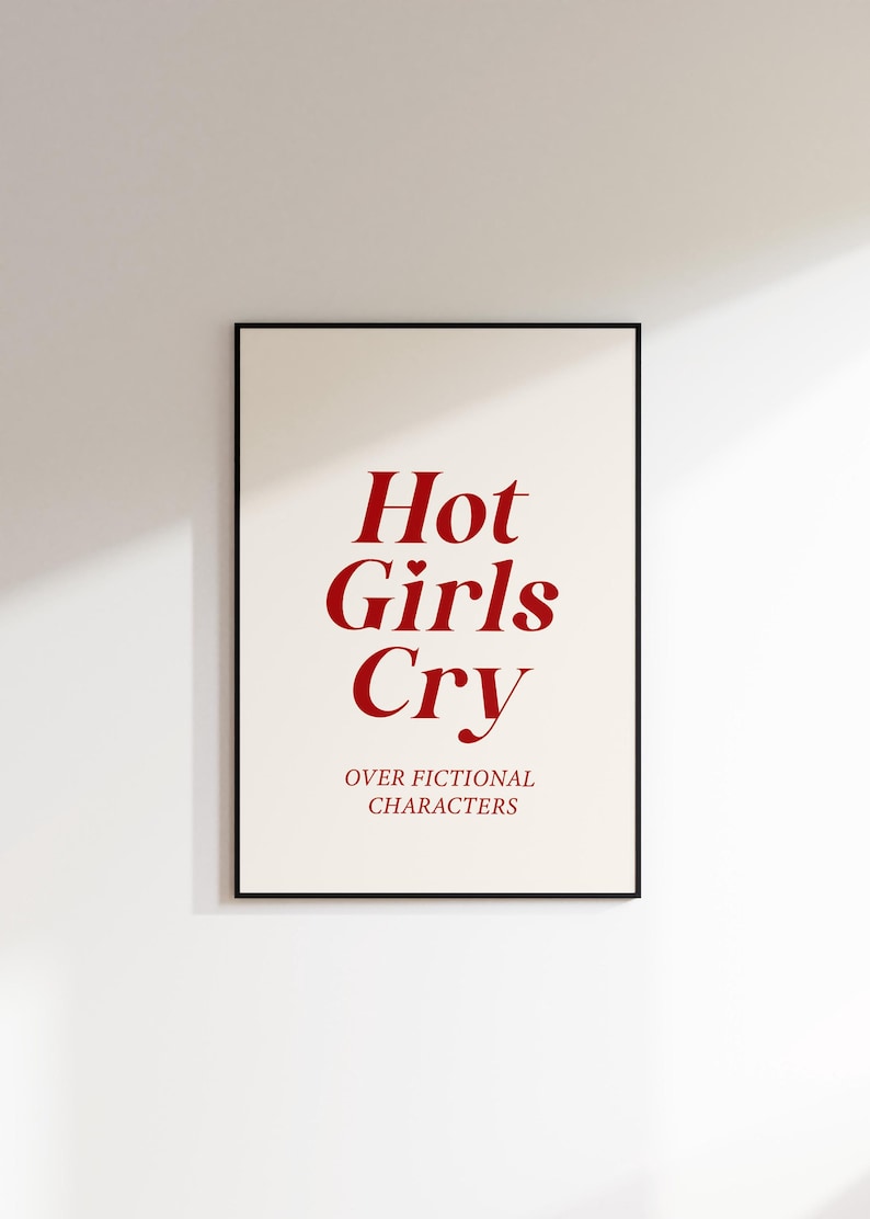 May include: A white framed poster with the text "Hot Girls Cry" in red font. Below the text is the phrase "over fictional characters" in smaller red font.