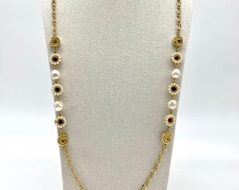 May include: Gold-tone necklace with alternating pearl and flower-shaped accents. The flower accents have a dark red center and a cream-colored border. The necklace also features spiral and chain links.