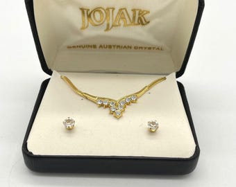 Conjunto de collar y pendientes JOJAK en tono dorado con cristales austriacos en forma de V. Joyería delicada.