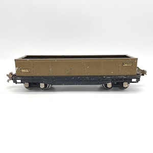May include: A vintage toy train car in brown and black. The car has the text "Lionel Lines" and "No. 812" printed on the side. The toy train car is a classic collectible item.