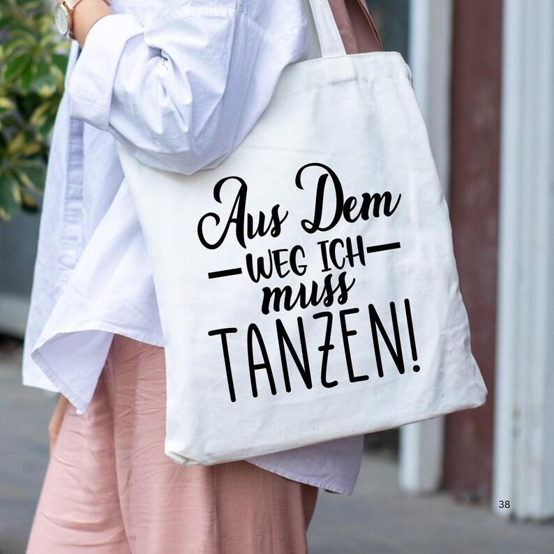 K&ouml;nnte beinhalten: Eine wei&szlig;e Einkaufstasche mit schwarzem Text, der "Aus Dem -Weg Ich- muss TANZEN!" lautet.