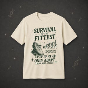 Peut inclure: Un t-shirt couleur crème avec un motif vert foncé représentant Charles Darwin, une séquence d'évolution, un brin d'ADN et cinq têtes d'oiseaux. Le texte indique SURVIVAL OF THE FITTEST, ONLY ADAPT et THOSE WHO ENDURE.