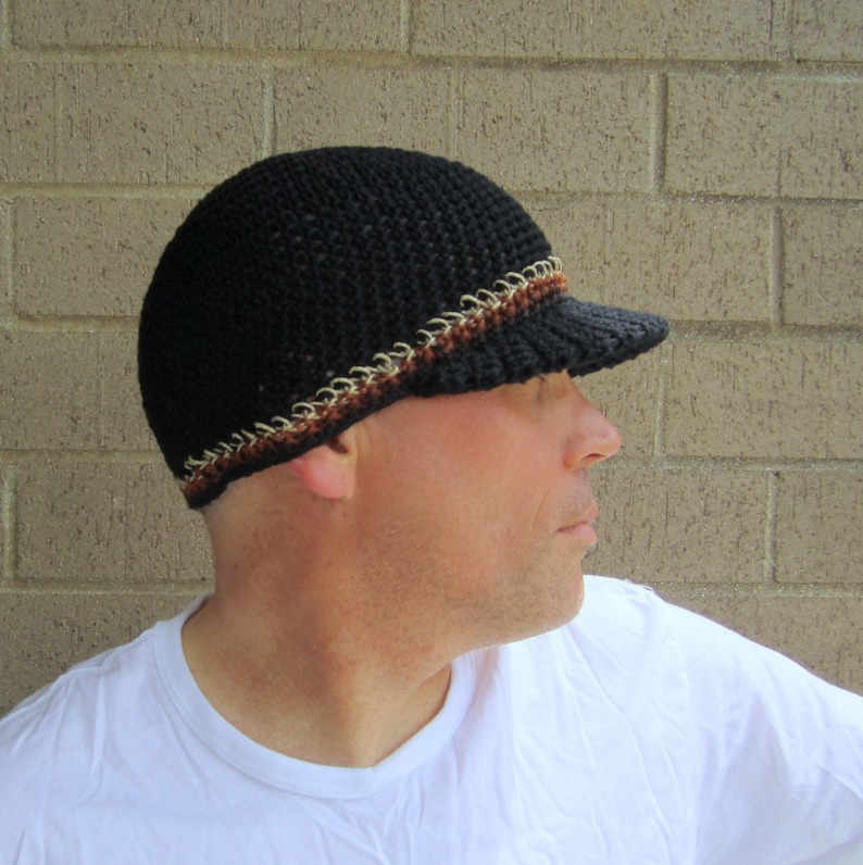 The model is wearing a black, crocheted beanie with a bill...there is a trim of brown and natural hemp yarn near the bottom of the hat- it fits snugly and almost covers his ears.
