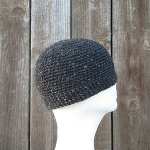 May include: A black crocheted beanie with a flecked texture. The beanie is on a white mannequin head.