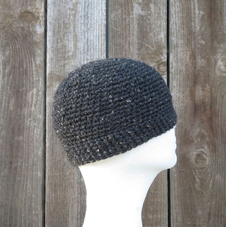 May include: A black crocheted beanie with a flecked texture. The beanie is on a white mannequin head.