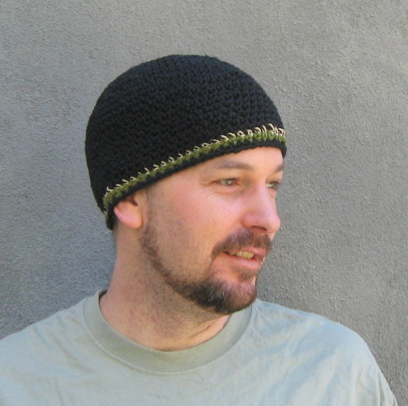The model is wearing a short, black, crocheted beanie with a stripe of natural hemp yarn and olive near the bottom of the hat...it fits snugly and almost covers his ears.