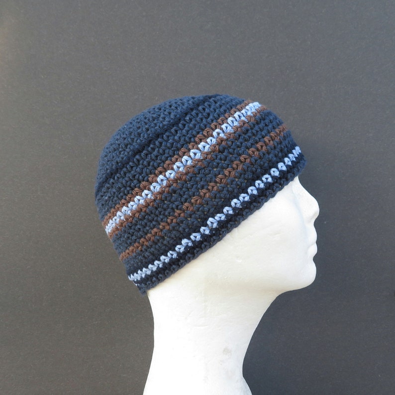 The mannequin is wearing a short, denim blue, crocheted skull cap with stripes of navy blue, brown and light blue running at intervals throughout...it fits snugly and will only just cover your ears.