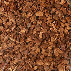 May include: Close-up of a pile of dried, brown, bark-like pieces. The pieces are irregular in shape and size, with some being long and thin, while others are short and thick.