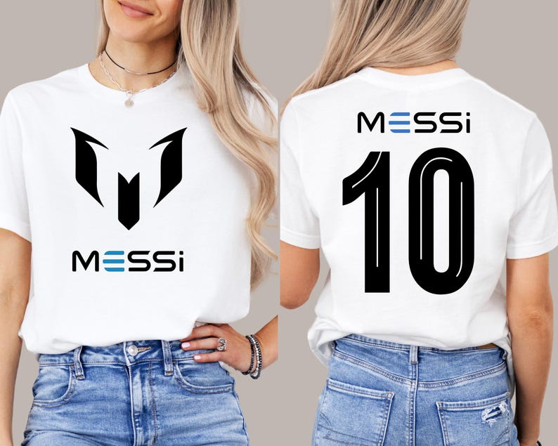 May include: White t-shirt with a black graphic of the letter "M" and the word "MESSI" in blue and black. The back of the shirt has the number "10" in black with the word "MESSI" in blue and black.