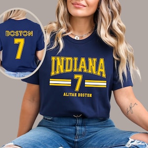 May include: A navy blue t-shirt with the text "INDIANA 7 ALIyah BOSTON" in yellow and white. The back of the shirt has the text "BOSTON 7" in yellow.