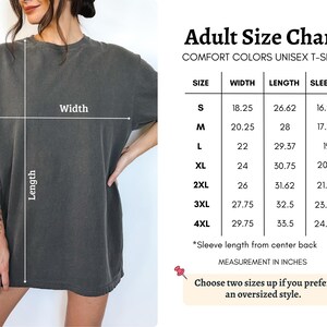 K&ouml;nnte beinhalten: Dunkelgraues Unisex-T-Shirt mit Gr&ouml;&szlig;entabelle. Die Tabelle enth&auml;lt Ma&szlig;e in Zoll f&uuml;r Breite, L&auml;nge und &Auml;rmell&auml;nge f&uuml;r die Gr&ouml;&szlig;en S bis 4XL. Der Text empfiehlt, zwei Gr&ouml;&szlig;en gr&ouml;&szlig;er zu w&auml;hlen, um einen &uuml;bergro&szlig;en Stil zu erhalten.