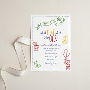 Puede incluir: Una tarjeta de invitaci&oacute;n blanca con un borde azul punteado, con ilustraciones coloridas de osos de peluche, un avi&oacute;n y globos. El texto incluye "PARTY TIME!" y "what FUN it is to be ONE!" para una celebraci&oacute;n de primer cumplea&ntilde;os.