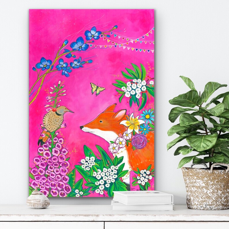 May include: A whimsical painting of a fox and a bird in a vibrant pink landscape. The fox is orange with white markings and is surrounded by colorful flowers. The bird is brown and white with a long tail. The background is a bright pink with a string of colorful flags.