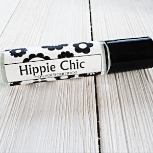 May include: A clear glass roller bottle with a black cap and a white label that says "Hippie Chic natural fragrance" with a black and white floral pattern.